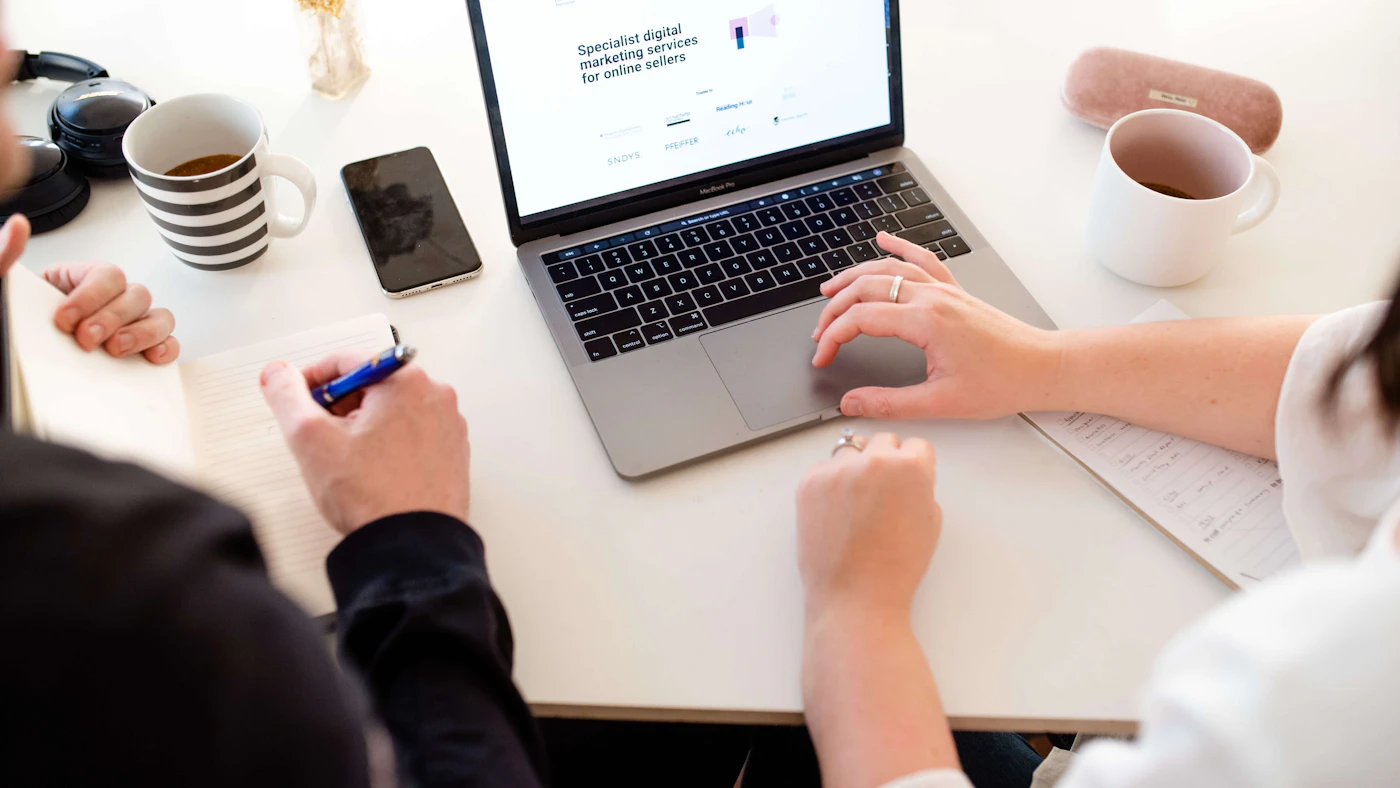 Two people working together on a marketing strategy at a laptop.