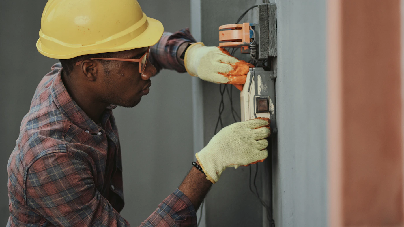 An electrician inspecting wiring on a work site.