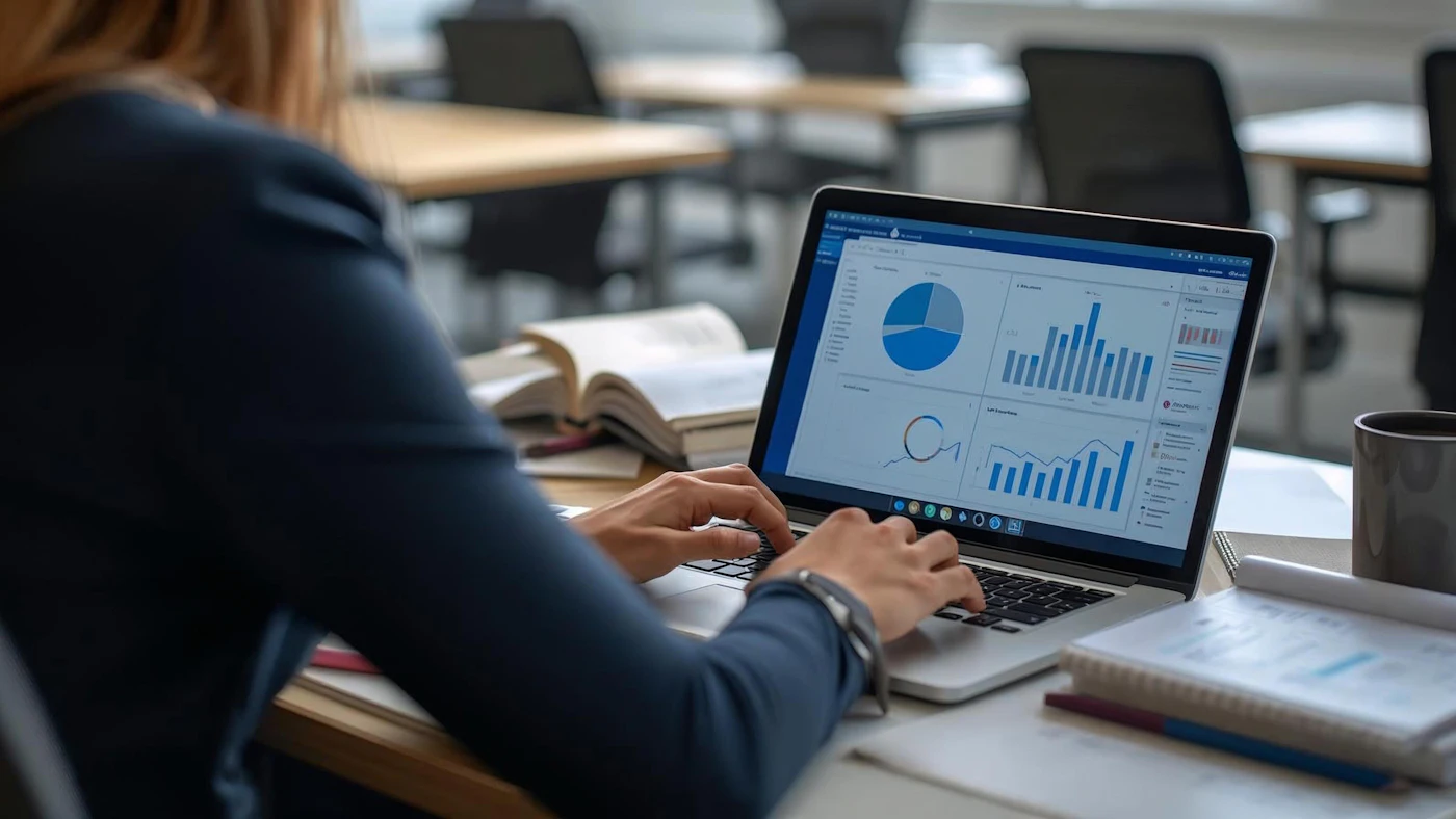 A person reviewing business charts and performance data on a laptop.