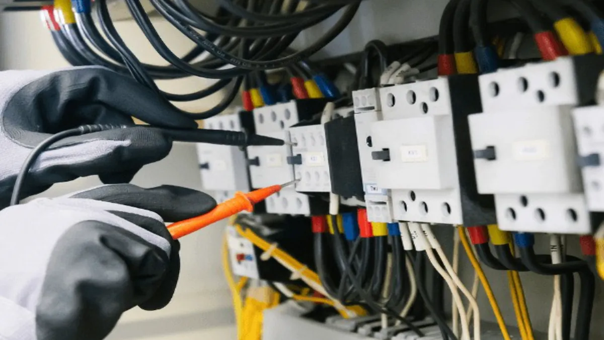Electrician testing wiring and components inside an electrical panel